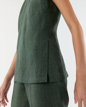 A person wears the Ann Mashburn Jo Tunic, a sleeveless dark green linen shell tank with princess seams, paired with matching pants, photographed from shoulder to knee against a plain background.