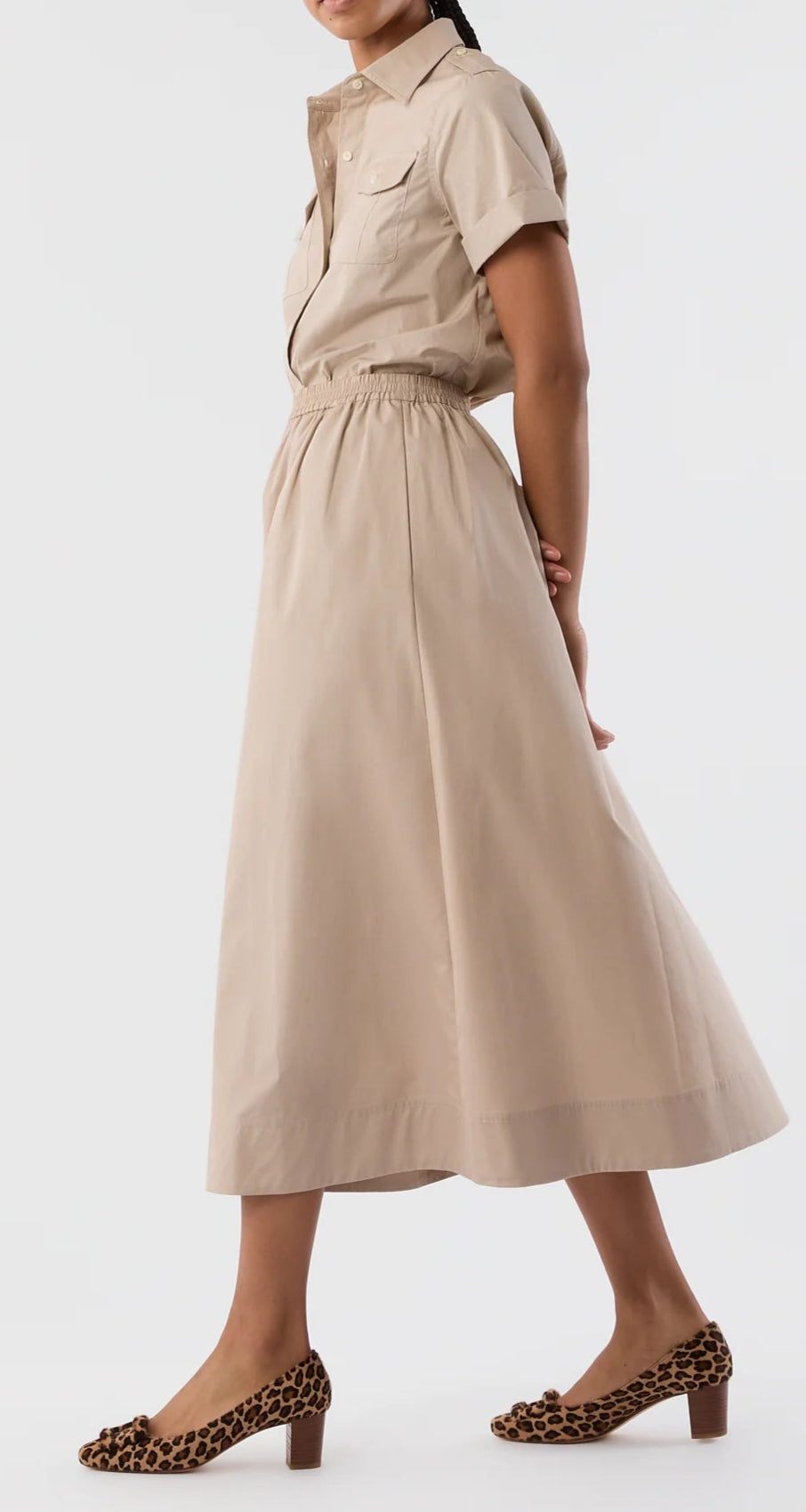 Miranda wears the Ann Mashburn Miranda Poplin Skirt, a beige Italian poplin midi skirt with an elastic waist, styled with a matching short-sleeve button-up shirt and leopard print block-heel shoes.