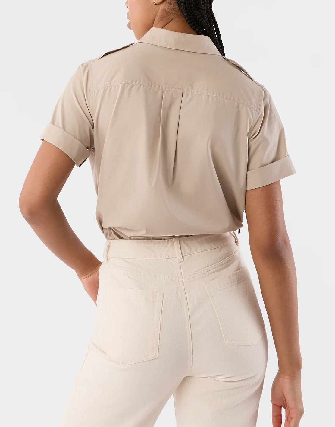 A person is seen from the back wearing the Ann Mashburn Short Sleeved Poplin Safari Shirt with rolled cuffs, paired with high-waisted, light-colored pants.