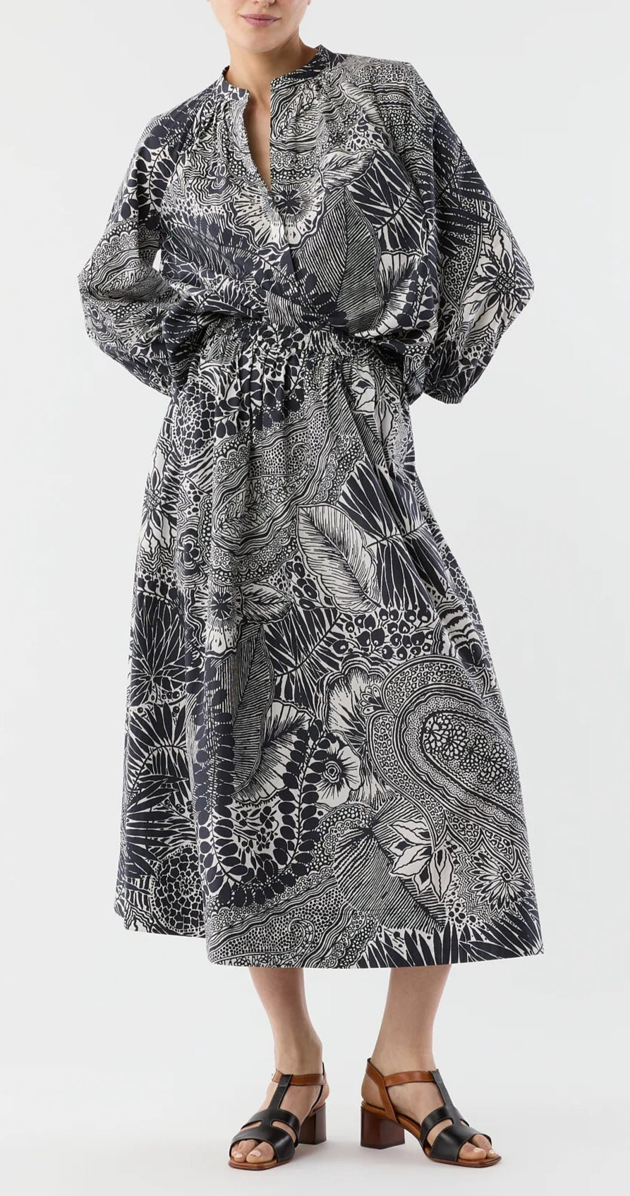 A person wearing the Miranda Block Print Skirt by Ann Mashburn, paired with black heeled sandals, stands against a white background.
