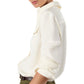 A person wearing the Ann Mashburn Hannah Blouse, a long-sleeve off-white utilitarian top with rolled-up sleeves, paired with olive green pants, shown in a side view.