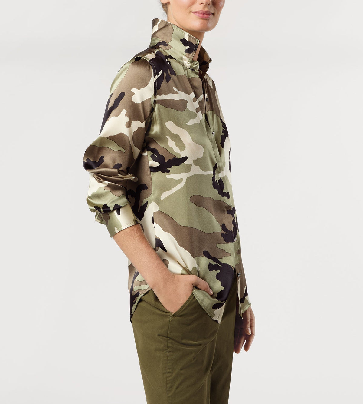 Person wearing an Ann Mashburn Classic Silk Charmeuse Blouse in a green and brown camouflage print with olive green pants.