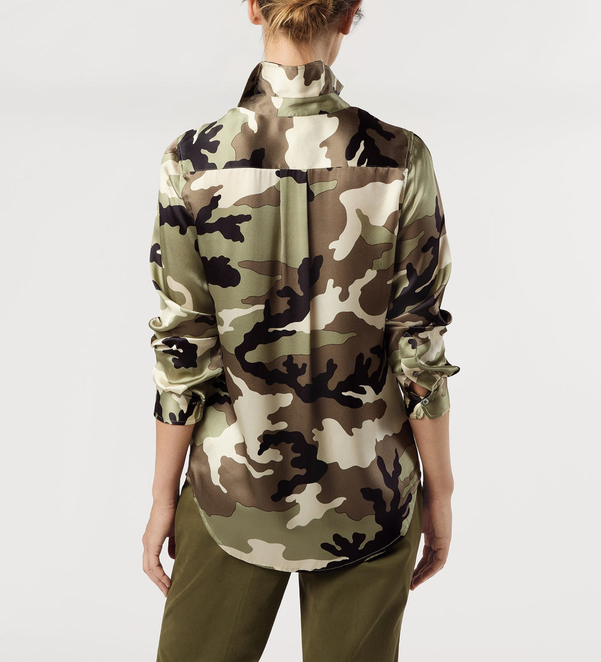 Back view of a person wearing an Ann Mashburn Classic Silk Charmeuse Blouse featuring a camouflage print, long sleeves, and a collared neckline.