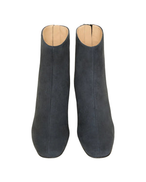 A pair of Ann Mashburn Zip-Back Boots in dark gray lamb suede is shown from above, highlighting the rounded toes and beige inner lining.