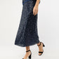 Person wearing the Ann Mashburn Ruby Beaded Mesh Skirt with a matching top and black block-heeled sandals, standing against a plain white background.