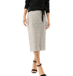 A person wears the Ann Mashburn Sequin Pull-On Skirt, a black long-sleeve top, and black ankle-strap sandals while standing against a white background.