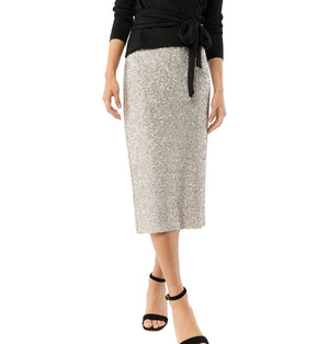A person wears the Ann Mashburn Sequin Pull-On Skirt, a black long-sleeve top, and black ankle-strap sandals while standing against a white background.
