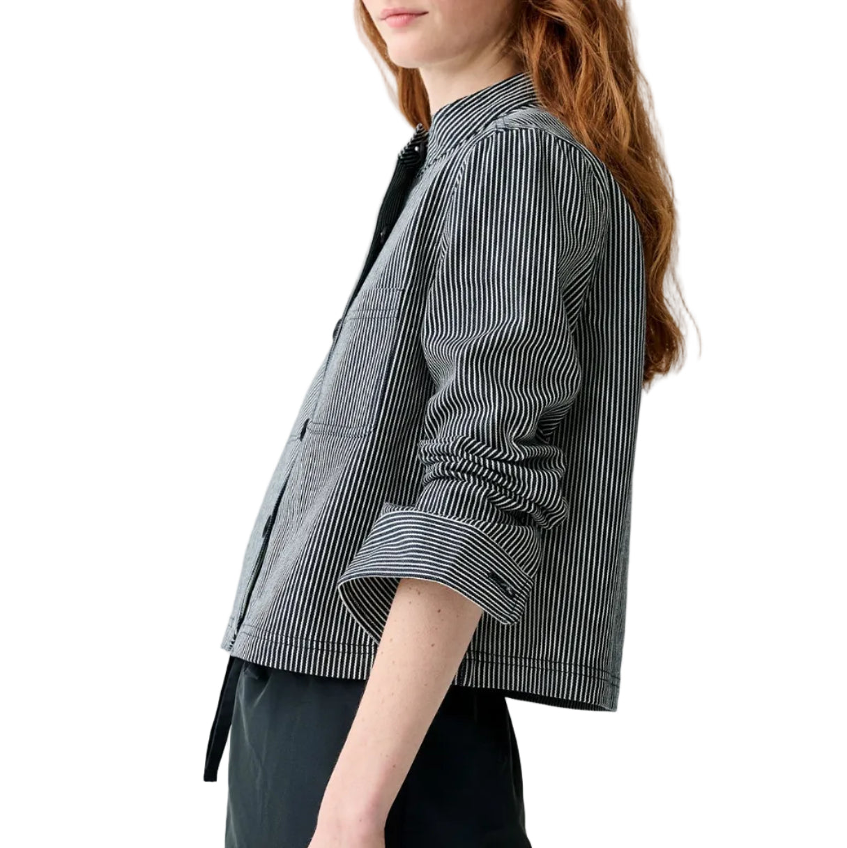 A person wearing the Ann Mashburn Short Chore Jacket with railroad stripes and rolled-up sleeves over a collared shirt, shown from the side against a white background.