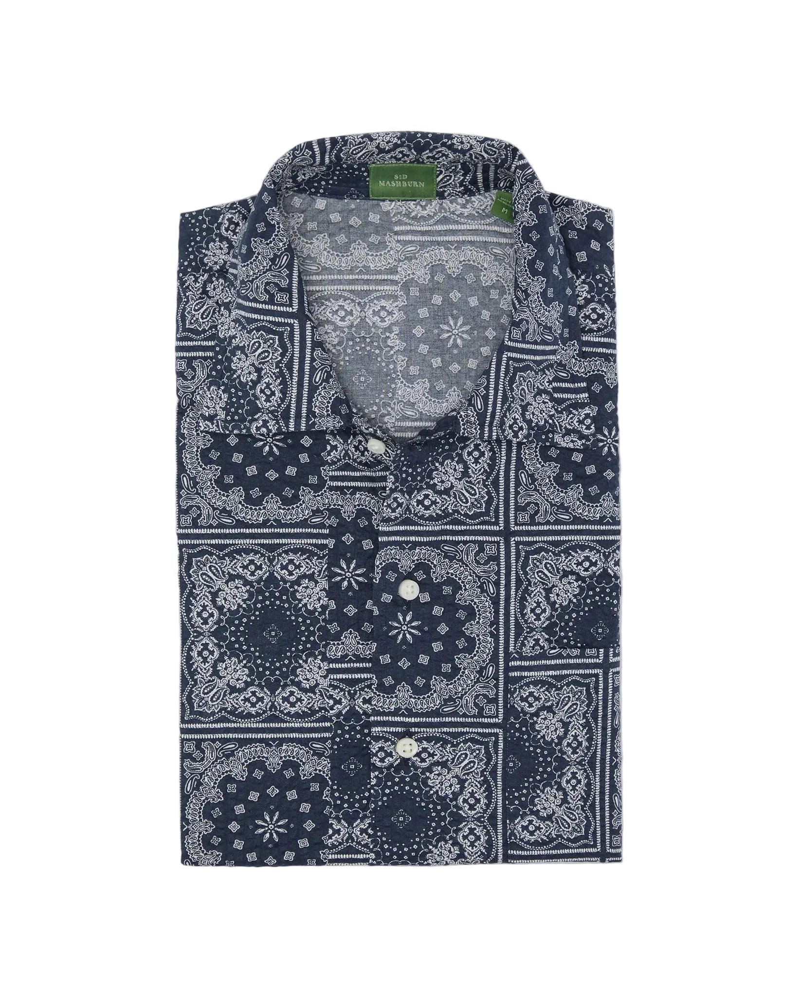 Sid Mashburn Ripley Shirt—an updated nod to the classic 1950s vacation shirt, this long-sleeve, patchworked paisley shirt features a blue and white bandana print, button front, and visible green tag inside the collar.
