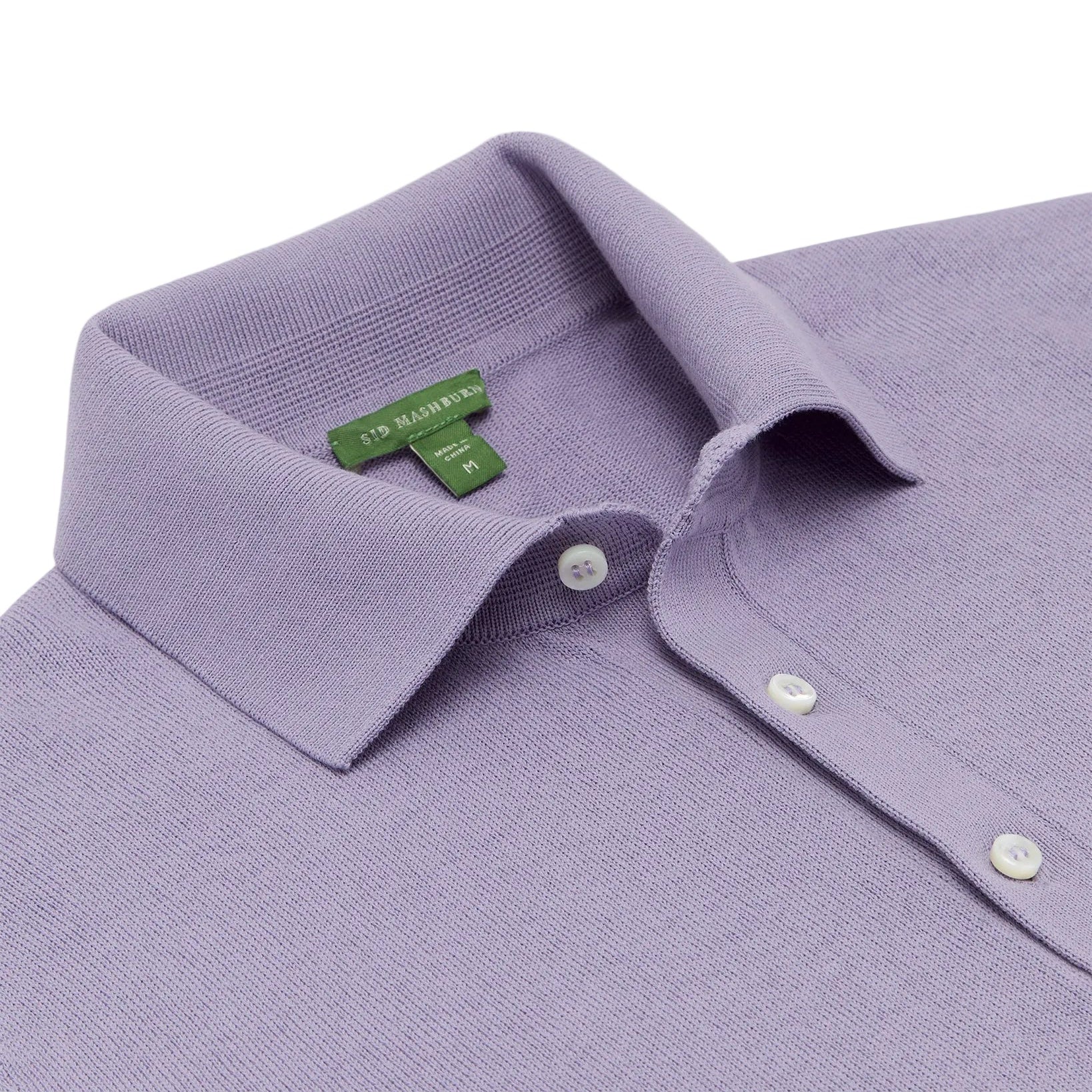A neatly folded lavender Sid Mashburn Short-Sleeved Rally Polo Sweater in a slim fit, featuring white buttons.