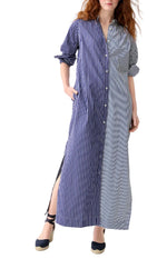 A woman wears the Ann Mashburn Mandarin Talitha Mixed Stripe Poplin Shirtdress, a long Italian poplin caftan with blue and white vertical stripes, rolled sleeves, and side slits.