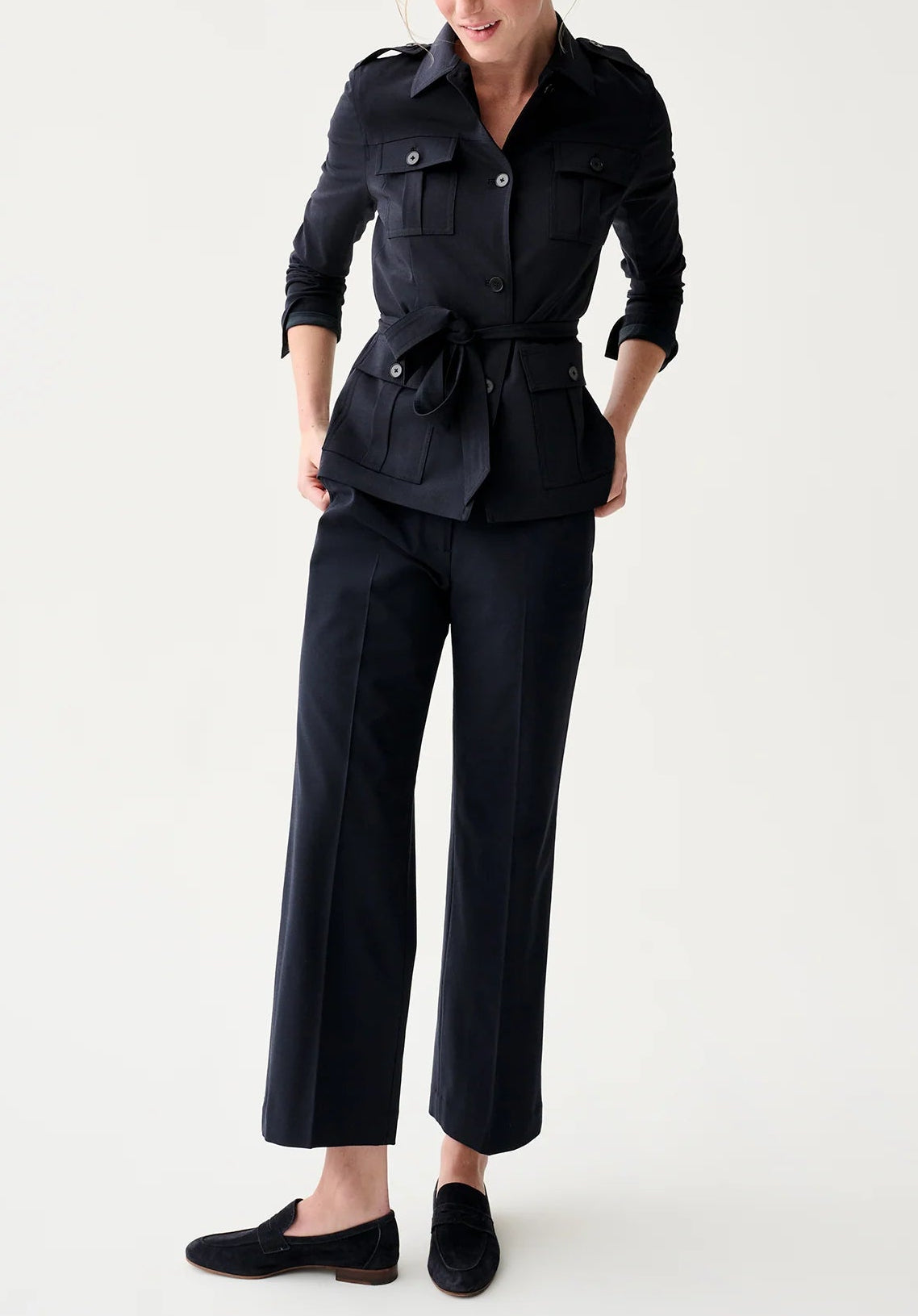 A person wears the Ann Mashburn Safari Bi-Stretch Tropical Wool Jacket with flap pockets, matching wide-leg pants, and black loafers while standing against a plain light background.