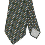A close-up of the Sid Mashburn Silk Print Tie, measuring 8cm in width and featuring a repeating pattern of curved shapes in green, brown, blue, and white. Both the tip of the tie and a portion of the reverse side are visible.