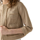 A woman wears the Ann Mashburn Kiki Stretch Canvas Jacket in beige with frayed edges and front pockets, paired with white pants, set against a white background.