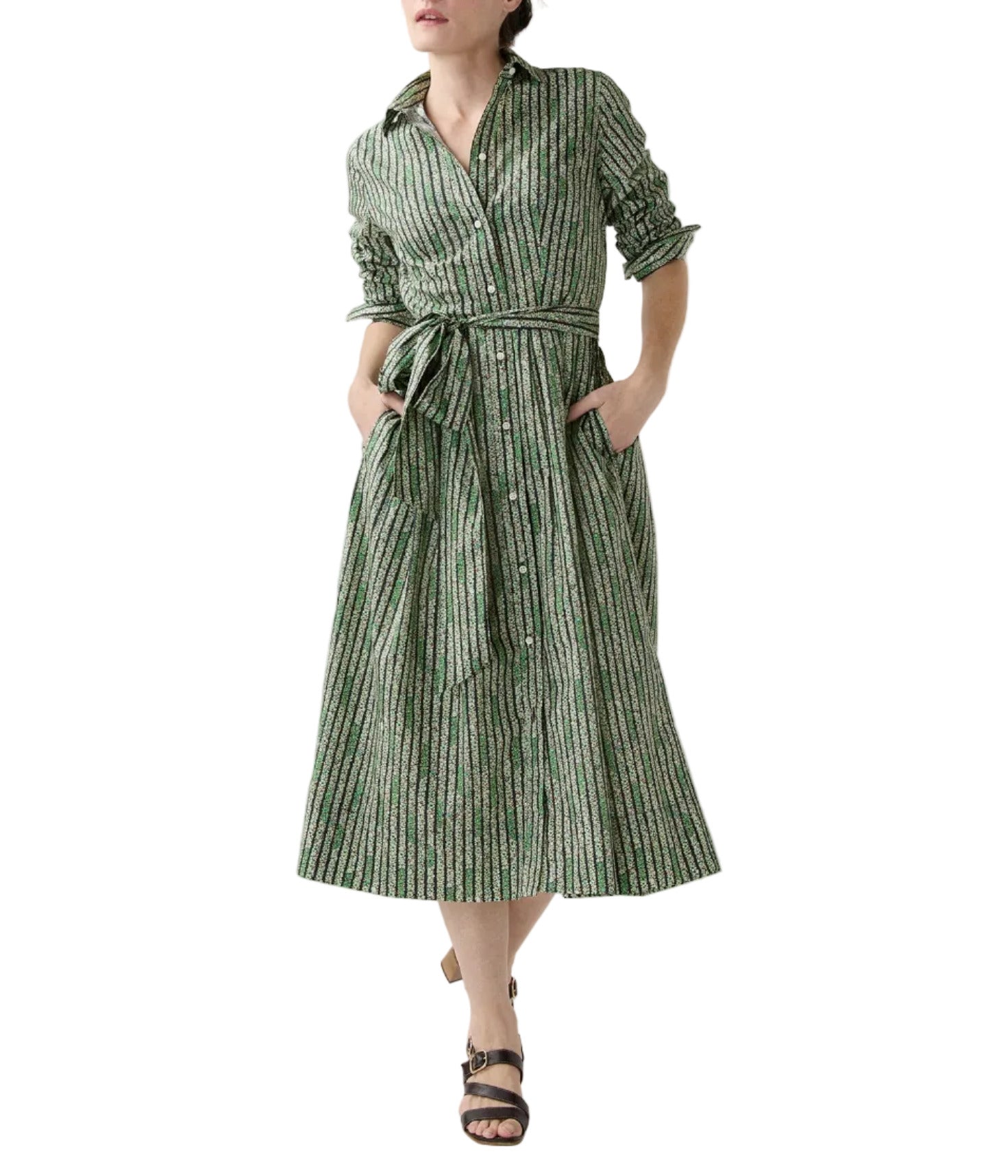 A woman wears the Ann Mashburn Classic Shirtwaist Floral Stripe Dress, featuring long sleeves, a collar, and a belt, styled with black sandals.