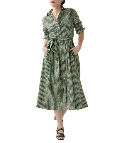 A woman wears the Ann Mashburn Classic Shirtwaist Floral Stripe Dress, featuring long sleeves, a collar, and a belt, styled with black sandals.