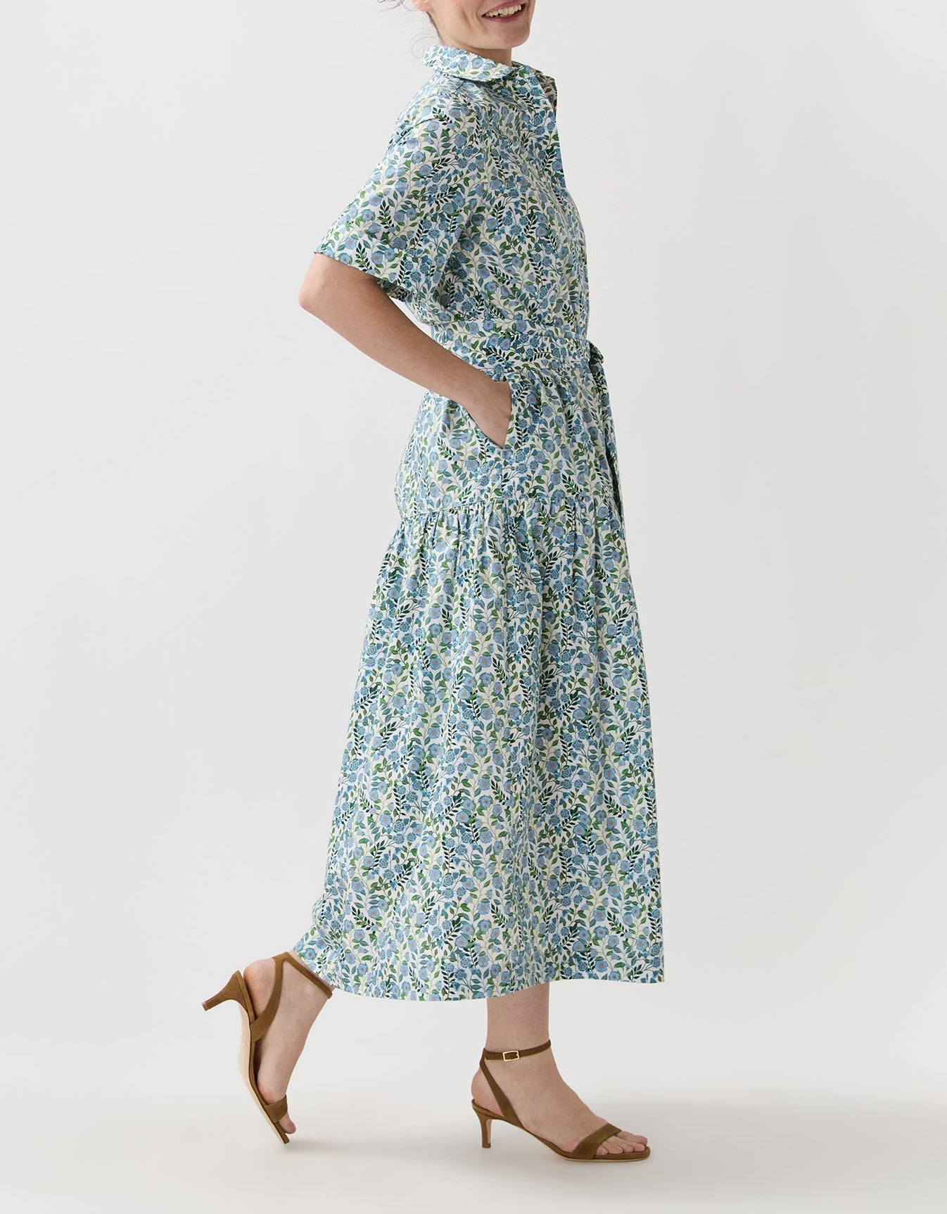 A person wearing the Ann Mashburn Nathalie Vigers' Vine Liberty Dress with short sleeves and tan heeled sandals, standing sideways against a plain white background.