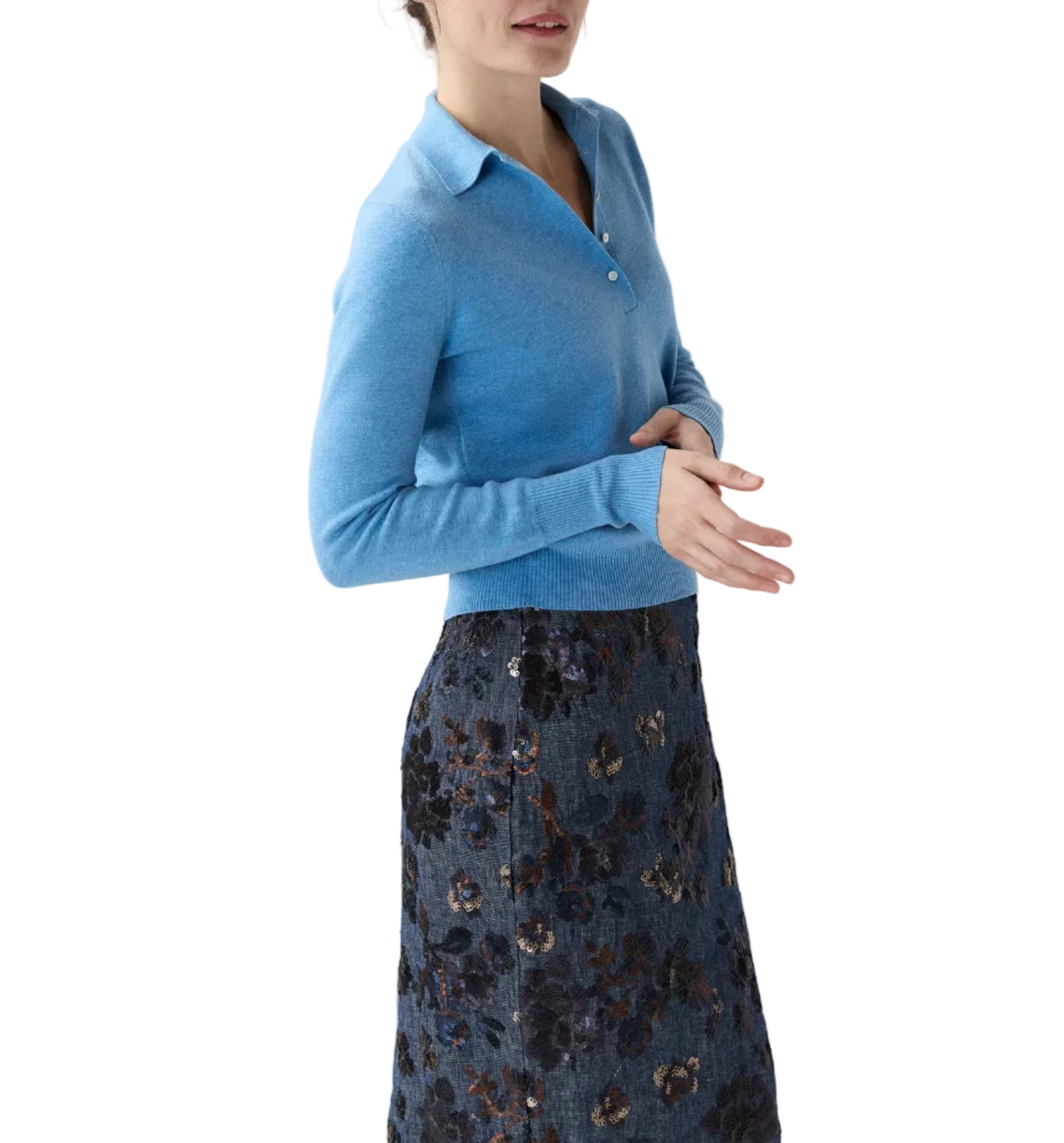 A woman wearing the Ann Mashburn Connor Cotton/Silk Sweater in light blue and a dark floral skirt stands against a white background.