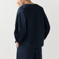 Person wearing the Ann Mashburn Meghan Top—a loose-fitting, long-sleeve navy blouson—paired with matching wide leg pants, shown from the back against a plain light background.