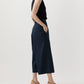 A person stands sideways in a blouson-style black sleeveless top, tan heeled sandals, and Ann Mashburn's Drew Pant—dark wide-leg cropped poplin trousers—set against a plain background.