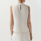 A woman, shown from behind, wears the Ann Mashburn Mimi Linen Top—a sleeveless shell in off-white Belgian linen with a small back keyhole—paired with a matching skirt.