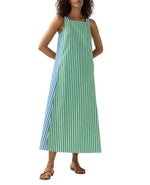 A woman wears the Ann Mashburn Lise Maxi Dress—an ankle-length, sleeveless A-line in blue and green striped Italian poplin—paired with brown flat sandals.