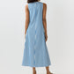 A woman faces away, wearing the Ann Mashburn Lise Maxi Dress—a sleeveless, ankle-length, A-line style in striped Italian poplin—with flat sandals, set against a plain light background.