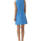 Woman shown from the back wearing the Ann Mashburn Susy Shift Dress—a sleeveless, knee-length blue dress with a white geometric pattern in a 1960s A-line silhouette—paired with beige heeled sandals.