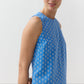 A woman models the Ann Mashburn Susy Shift Dress—a sleeveless, blue 1960s-style A-line dress with a white circular pattern in Japanese compact cotton—against a plain light background.