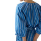 A person is shown from behind, hands back, wearing the Ann Mashburn Victoria Variegated Stripe Blouse in blue and white stripes, set against a crisp white background.