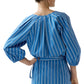 Model wears the Ann Mashburn Victoria Variegated Stripe Blouse, featuring blue and white stripes and balloon sleeves, shown from the back—an ideal Italian poplin piece for spring.