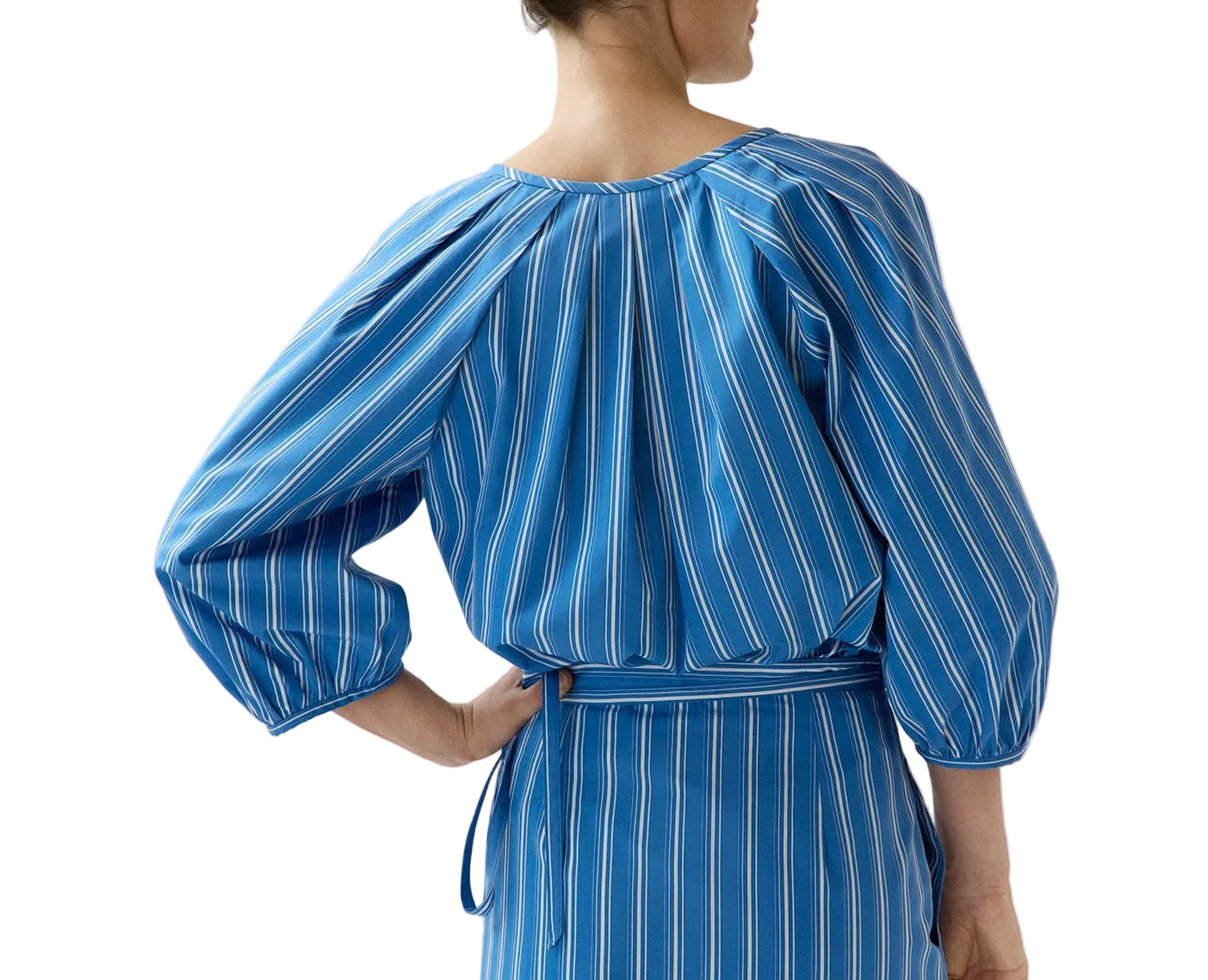 Model wears the Ann Mashburn Victoria Variegated Stripe Blouse, featuring blue and white stripes and balloon sleeves, shown from the back—an ideal Italian poplin piece for spring.