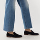 Person wearing blue straight-leg jeans and Ann Mashburn’s Mia Suede Loafer, standing against a plain background.