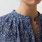 Close-up of the Sienna Crinkle Cotton Top, a blue floral print billowy blouse with a split neckline, pleated shoulder details, and romantic sleeves.