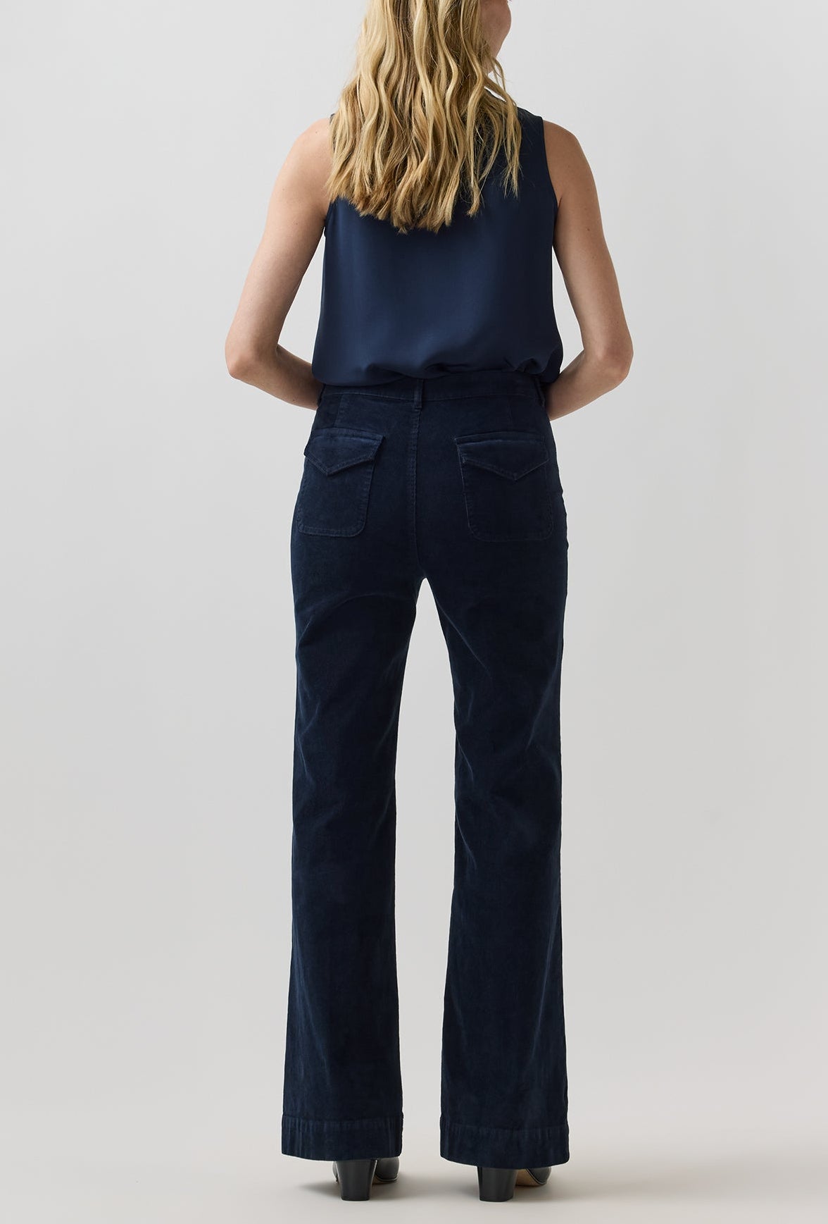 Back view of Ann Mashburn Camille Patch-Pocket Stretch Corduroy Jean in dark navy cotton with two large rear patch pockets, worn with a sleeveless navy top.