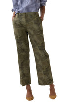 A person wears the Ann Mashburn Frankie Stretch Twill Cropped Pant in a camo print, featuring a barely-there waistband, paired with a blue checkered shirt with rolled sleeves and brown flats, standing against a plain background.