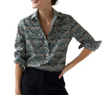 A woman wearing an Ann Mashburn Tomboy Popover Liberty Shirt in a dark floral and bird print.