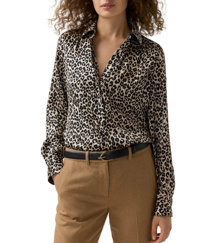 A woman wears a leopard print Natalia Silk Blouse tucked into tan trousers with a black leather belt.