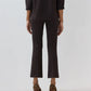 A person stands facing away against a plain background, wearing the Ann Mashburn Faye Flare Cropped Pant and a matching three-quarter sleeve top, paired with brown leopard-print heeled shoes.