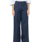 A person wearing a white blouse, black sandals, and Callas Milano Sailor Pant in navy cotton twill with front seams stands against a plain background.