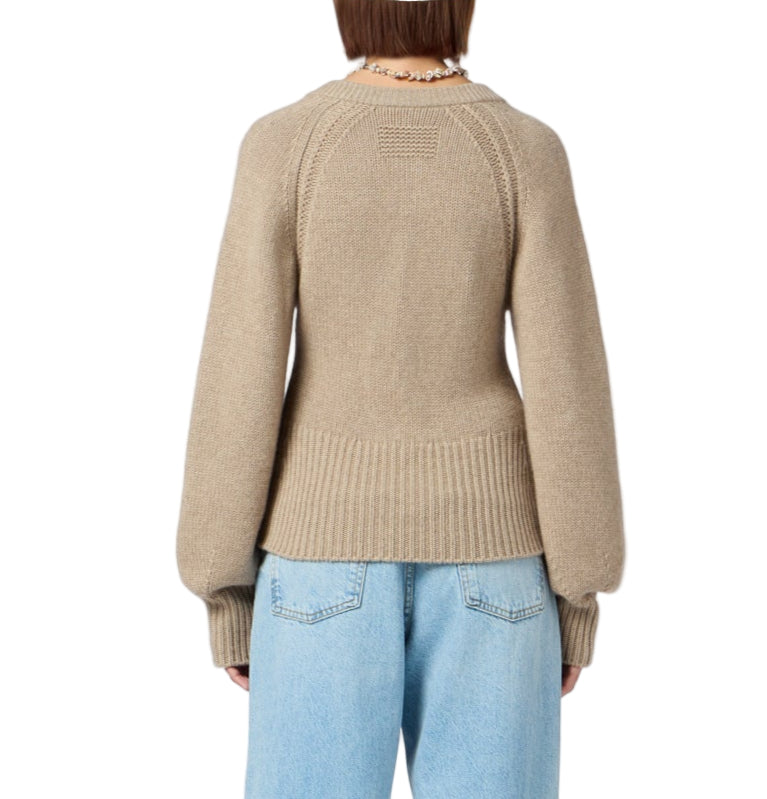 Model wearing the Sculpted Cardigan by Guest in Residence—a beige cropped, puff-sleeve knit—paired with light blue jeans, shown from the back against a plain background.