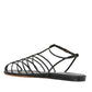 Explore the sophistication of Proenza Schouler's Tee Cage Flat Sandals, showcasing a black cage-style design with multiple thin straps and a sleek flat sole, viewed from the side.