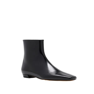 The Proenza Schouler Trap Flat Ankle Boots in shiny black nappa leather feature a square toe and low heel, displayed on a white background.
