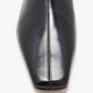 Close-up of the shiny black square-toed Trap Flat Ankle Boots by Proenza Schouler in nappa leather, featuring a central seam detail.