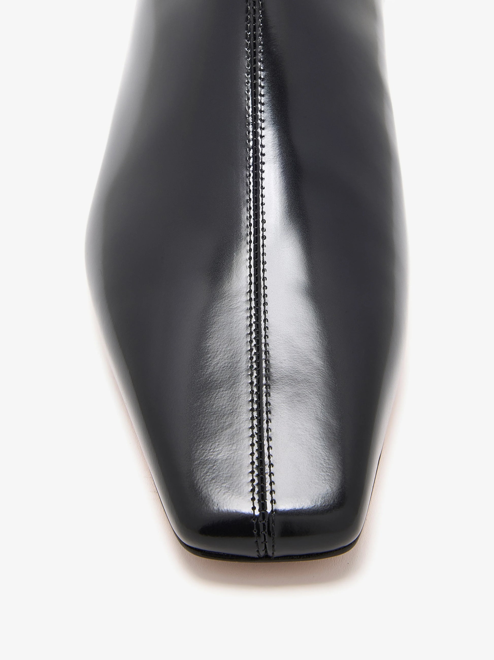 Close-up of the shiny black square-toed Trap Flat Ankle Boots by Proenza Schouler in nappa leather, featuring a central seam detail.
