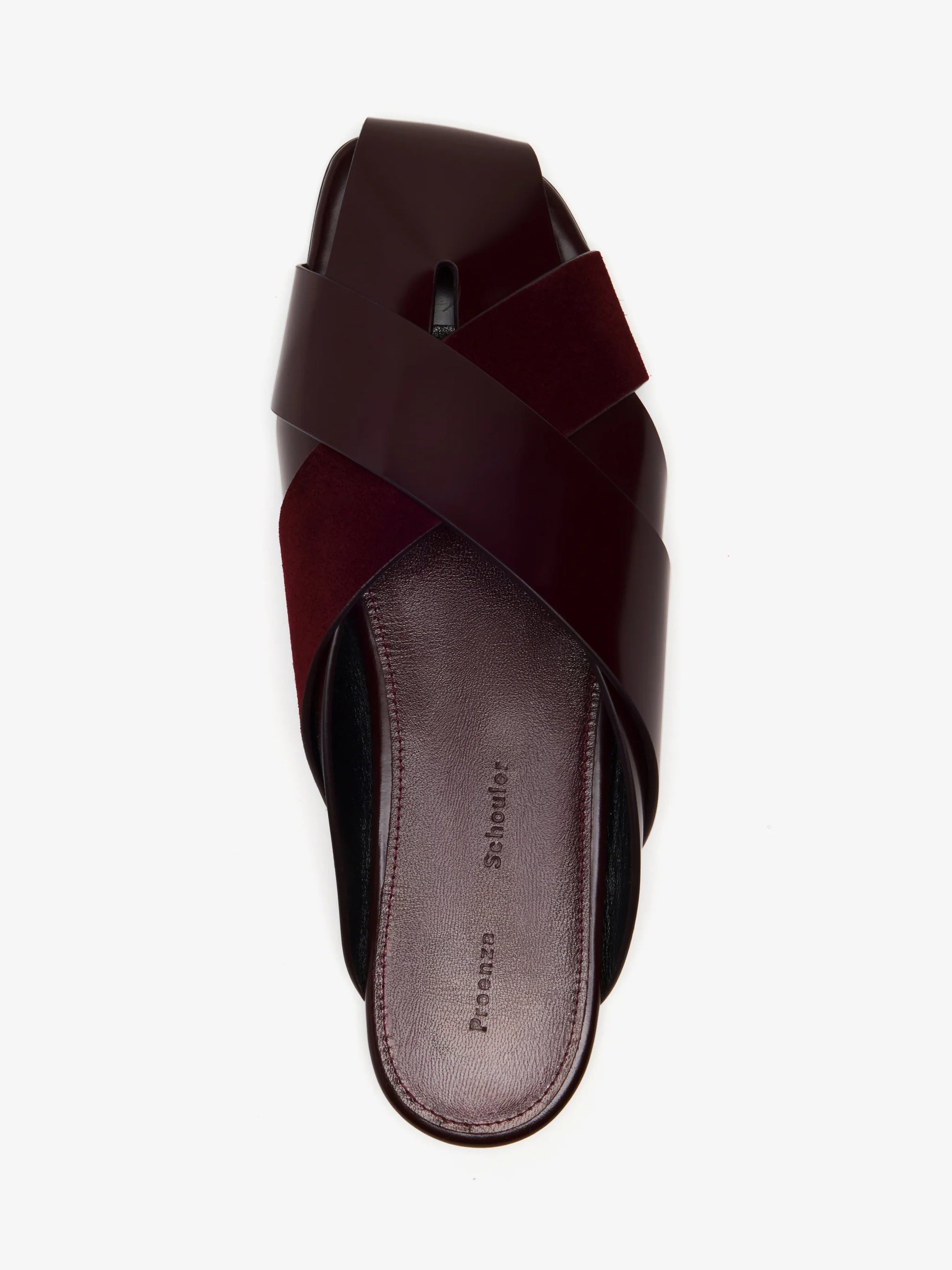 The Proenza Schouler Slant Cross Slides in maroon feature wide crisscross calf suede straps and a slightly textured footbed, shown here from a top-down view.