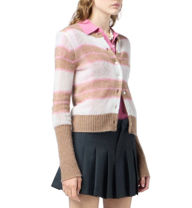 A woman wears the Guest in Residence Shadow Plaid Cardigan over a pink collared shirt, paired with a dark pleated skirt.