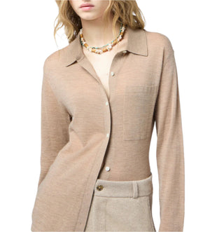 A woman models the Guest in Residence Showtime Cashmere Shirt with a pocket, paired with beige trousers and a colorful beaded necklace, against a white background.