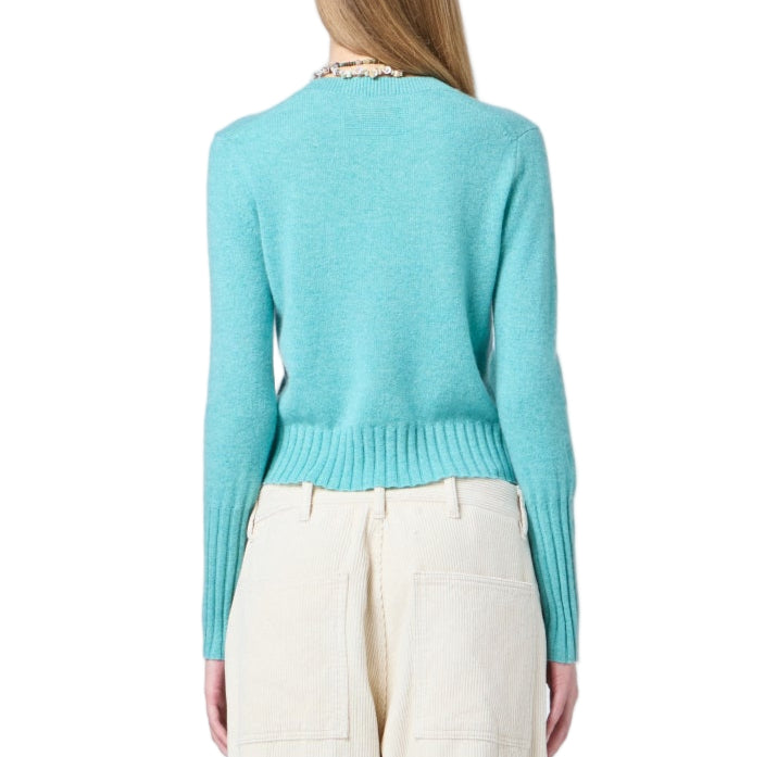 A person is shown from the back against a white background wearing Guest in Residence's Shrunken Crew Cashmere Sweater in light blue and high-waisted cream pants.