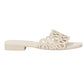 The Simkhai McCall Laser Cut Flat Slide is a beige supple leather sandal with an open toe, low heel, and a decorative upper strap featuring swirling laser perforations and softly scalloped edges.